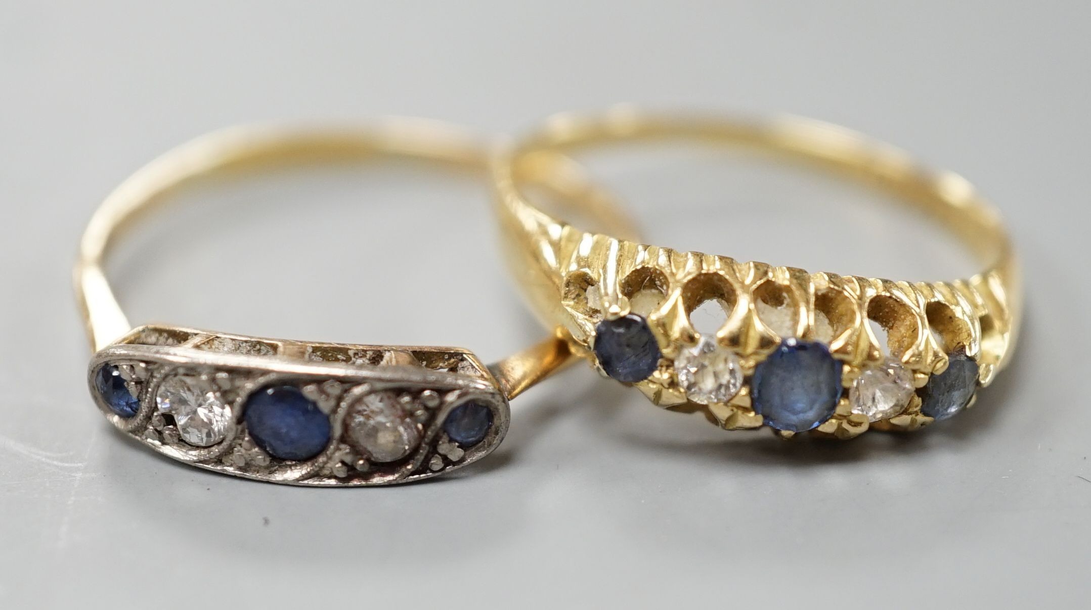 Two early 20th century yellow metal, sapphire and diamond set half hoop rings, sizes P & T, gross weight 5 grams.